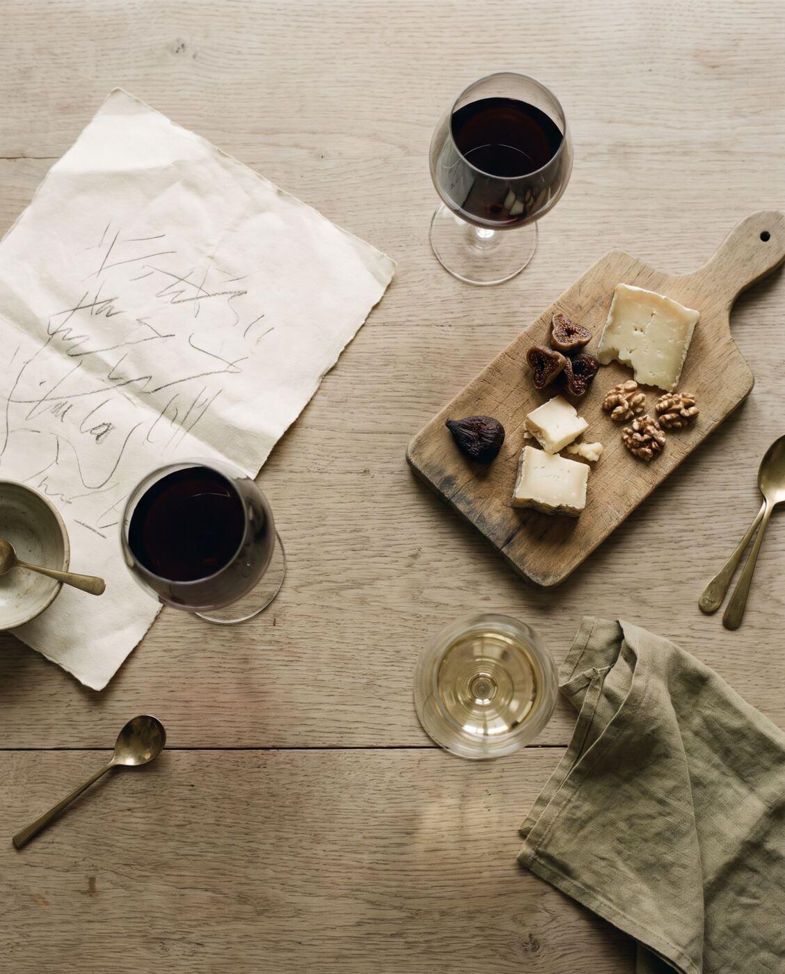 Mesa de cata con copas, notas a mano, quesos e higos